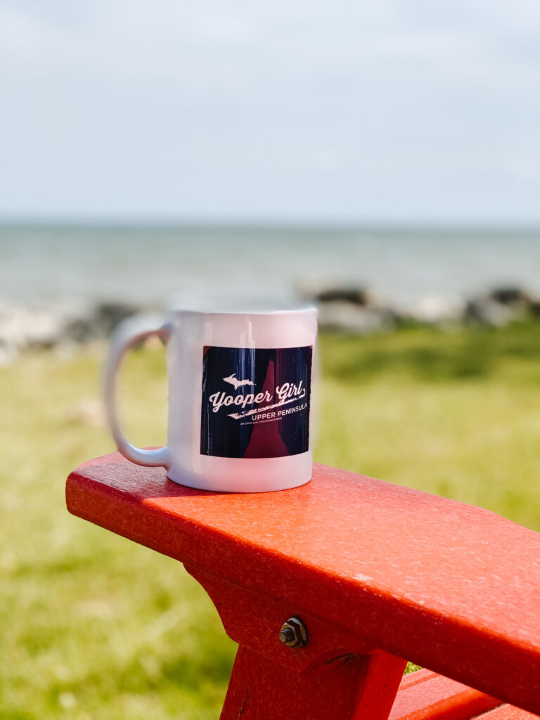 Yooper Girl 11 oz mug on red adirondack on Lake Michigan